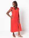 Woman wearing a red dress made using a style arc Esther woven dress sewing pattern with bow shoulders on a white background