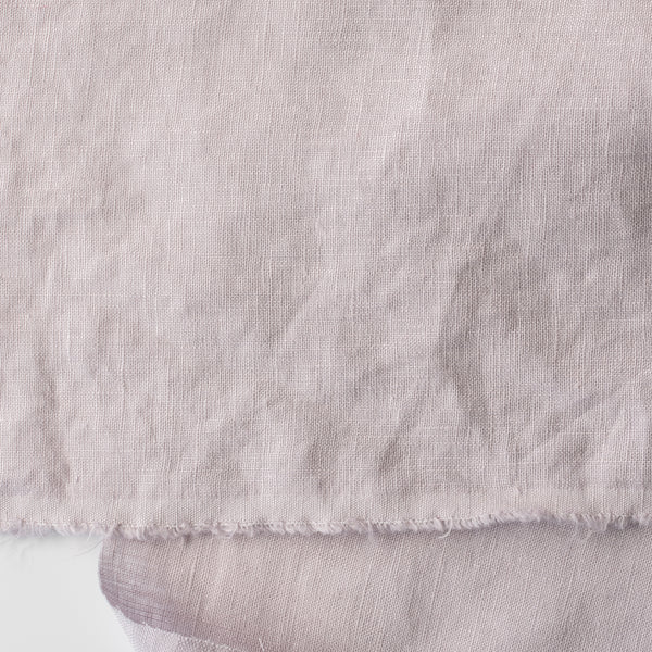 Close-up of light lilac-mauve inen fabric with visible texture