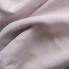 Close-up of light lilac-mauve inen fabric with visible texture