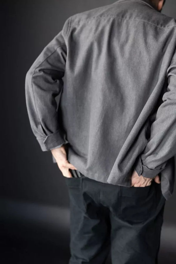 Person wearing a gray shirt and dark Elling Men’s Trouser against a dark background
