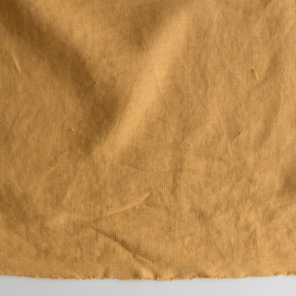 Close-up of Autumn Mustard extra wide 280cm 100% linen fabric 300gsm for jackets, aprons, cushions, curtains and structured home textilest gray background