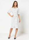 Woman wearing a white dress with black polka dots made using Avon Woven Shirt and Dress sewing patternon a white background
