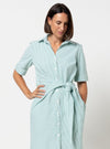 Woman wearing a light blue striped dress made using Avon Woven Shirt and Dress sewing pattern on a white background