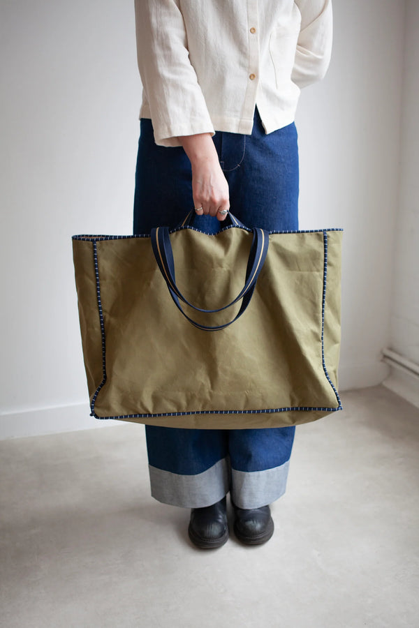 Person holding a large green tote bag made using the Away Tote PDF Sewing Pattern against a plain background
