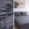 Gray fitted sheet on a bed with close-up details and a bedroom setting.