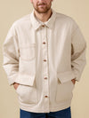 Man wearing a beige jacket with button details on a beige background