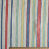 Striped fabric with red, blue, green, and yellow lines on a white background, with a ruler at the bottom for scale.