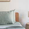 Bed with Harbour Sage linen pillowcasesin a bedroom setting