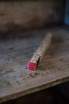 Merchant & Mills 1-metre wooden folding rulerwith pink ends on a wooden surface