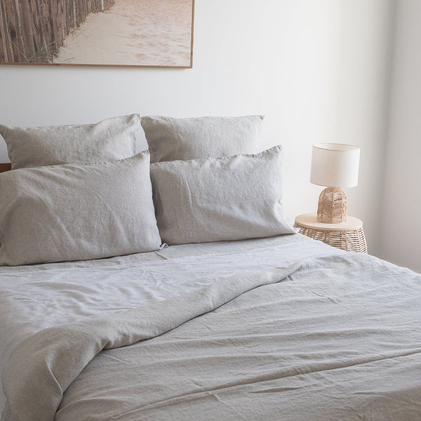 Neatly made bed withNatural linen fitted sheetand pillows in a bedroom setting.