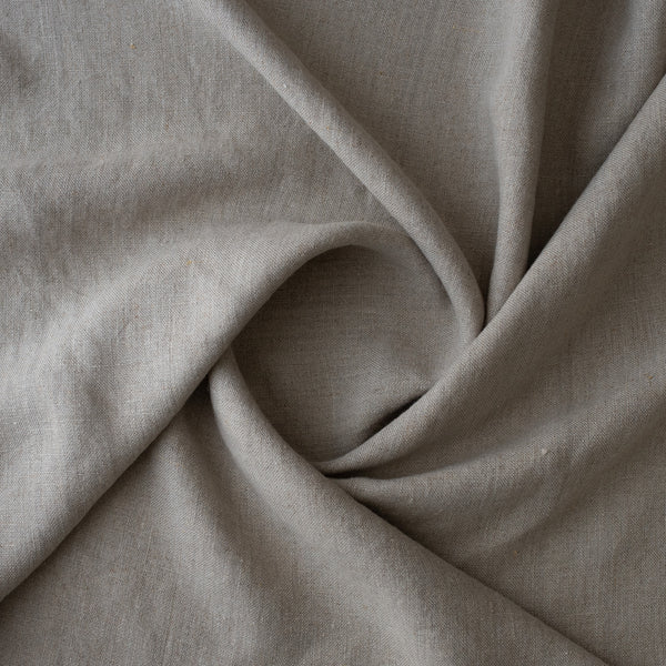 A close-up of drapedRaw Trace Extra Wide Heavy Linen Fabric Australia with a soft, textured weave, arranged in elegant folds.