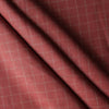 Close-up of Red Sand Check linen fabric in earthy brick red with teal twin pinstripes, 100% linen, 130 GSM, 60 LEA with a diagonal fold