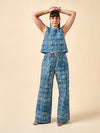 Woman wearing a blue geometric patterned outfit made using Sepia Pants and Shorts sewing patternon a beige background