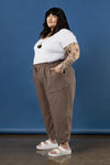 Woman wearing a white t-shirt and brown pants made using Sepia Pants and Shorts sewing patternagainst a blue background