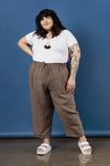 Person wearing a white t-shirt and brown pants made using Sepia Pants and Shorts sewing patternagainst a blue background
