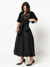 Woman wearing a black skirt made using Sophia Woven Bubble Skirt and Pant sewing pattern with lace detailing on a white background