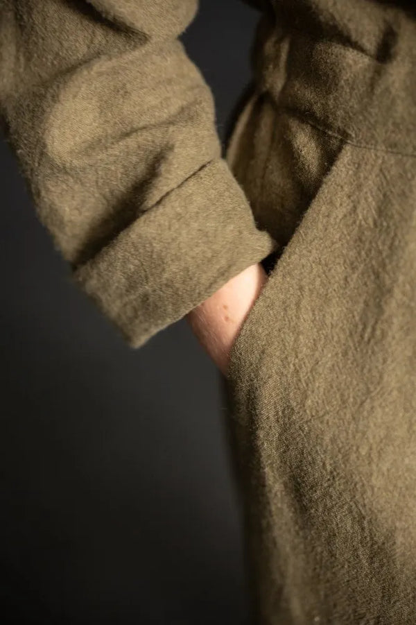 Close-up of a person wearing a green coat with a dark background