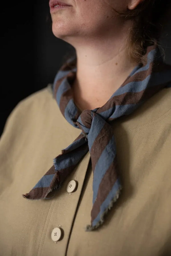 Person wearing a striped scarf with a dark background
