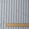 Alternating sky blue and midnight vertical stripes on a white linen blend fabric, with a natural slub texture and soft appearance.