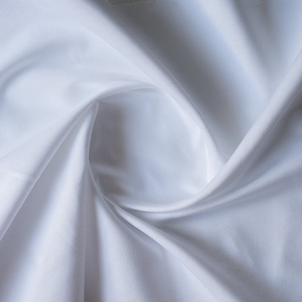 Close-up of Close-up of White Twill linen–cotton fabric showing subtle diagonal twill texture in pure white with folds