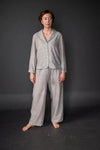 Person wearing a gray winnie pajama set against a dark background