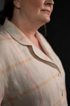 Close-up of a person wearing a plaid shirt with a dark background