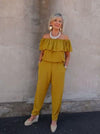 Elegant Barbara Jumpsuit with shoulder ruffle and pleated cuffs, alongside versatile pleated cuff pants pattern.