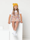 Chic Penny Teens swing dress or top sewing pattern featuring a shirred back panel, rouleau straps, and a faux button opening, designed for cotton, linen, and rayon fabrics